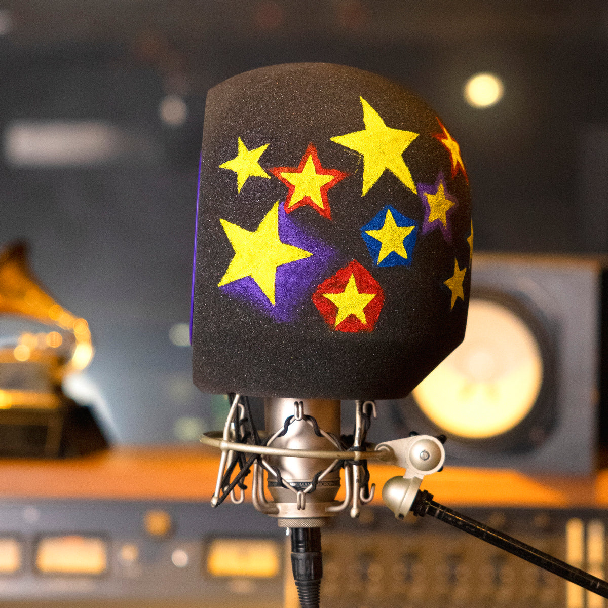 Comet Pro Microphone Isolation Shield with hand painted yellow blue red stars in studio background